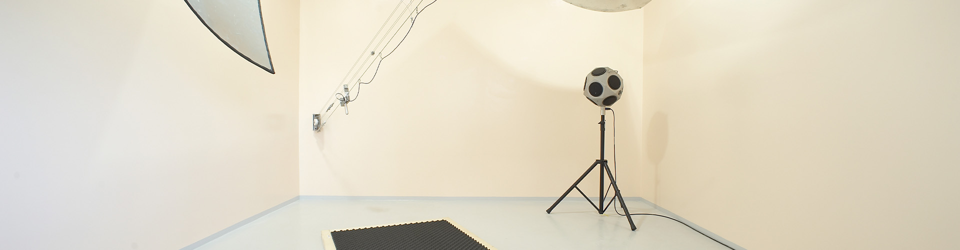 Leerer, schallharter Raum mit Messmikrofon und 360-Grad Lautsprecher darin